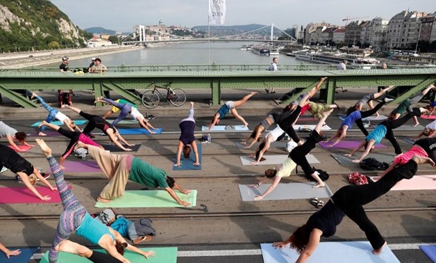 People practice yoga on Liberty Bridge in Budapest, Hungary, July 22, 2018. Picture taken July 22, 2018. REUTERS/Bernadett Szabo