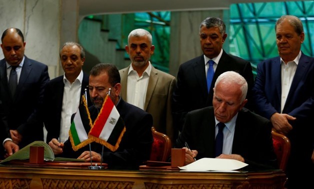 FILE - Head of Hamas delegation Saleh Arouri and Fatah leader Azzam Ahmad sign a reconciliation deal in Cairo, Egypt, October 12, 2017.