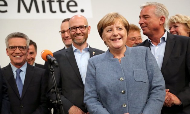 German Chancellor Angela Merkel (C) of the Christian Democratic Union (CDU) smiles on a stage in the late evening at the CDU election event in Berlin, Germany, 24 September 2017. According to federal election commissioner more than 61 million people were 