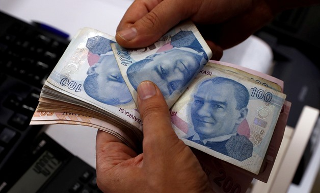FILE PHOTO: A money changer counts Turkish lira banknotes at a currency exchange office in Istanbul, Turkey August 2, 2018. Picture taken August 2, 2018. REUTERS/Murad Sezer
