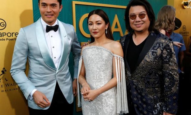 Author Kevin Kwan and cast members Henry Golding and Constance Wu pose. REUTERS/Mario Anzuoni.