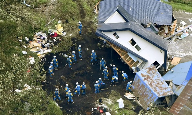 Police officers search for survivors from a house damaged by a landslide caused by an earthquake in Atsuma town, Hokkaido, northern Japan, in this photo taken by Kyodo September 7, 2018. Mandatory credit Kyodo/via REUTERS