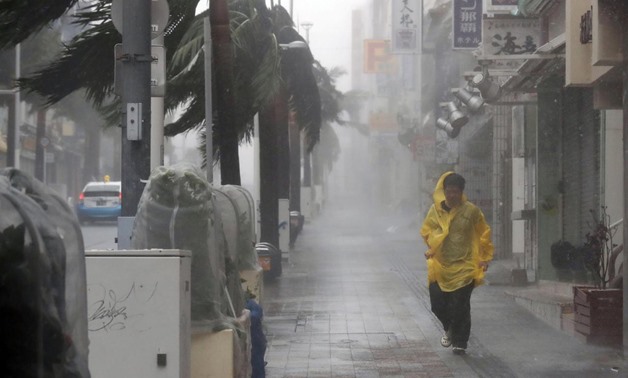 A passer-by walks in heavy rain and wind caused by Typhoon Trami in the prefectural capital Naha, on the southern island of Okinawa, in this photo taken by Kyodo September 29, 2018. Mandatory credit Kyodo/via REUTERS
