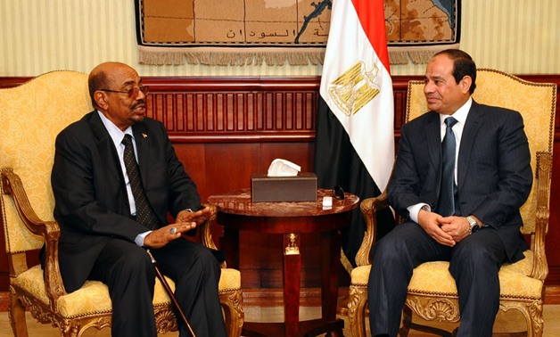 FILE – President Abdel Fatah al-Sisi (R) receives his Sudanese counterpart (L) Omar al-Bashir – AFP
