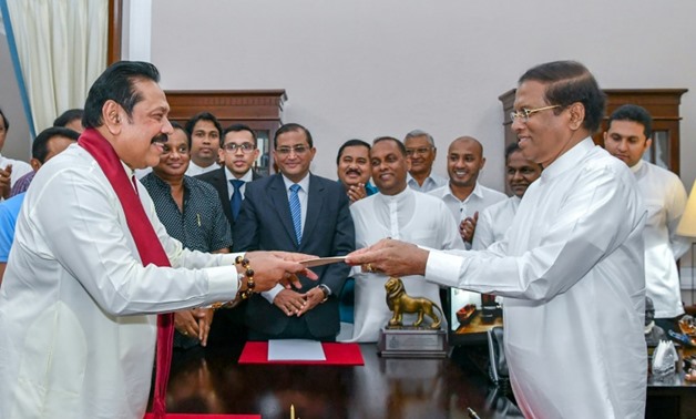 Former Sri Lankan president Mahinda Rajapakse, left, is sworn is as prime minister by President Maithripala Sirisena in Colombo, after incumbent premier Ranil Wickremesinghe was sacked
