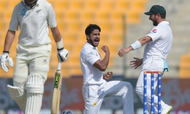 © AFP | Pakistan's Hasan Ali (C) celebrates with Yasir Shah after taking the wicket of New Zealand's Ross Taylor (L) during the third day of the first Test
