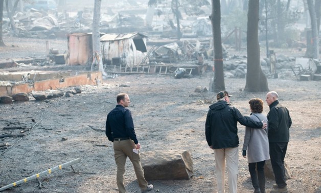 US President Donald Trump (C) hugged Paradise Mayor Jody Jones (2R) while surveying the remains of the California town of Paradise
