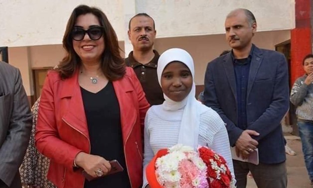 Damietta governor Manal Awad (L) grants Basmala Ali (R) flower bouquet - Press photo