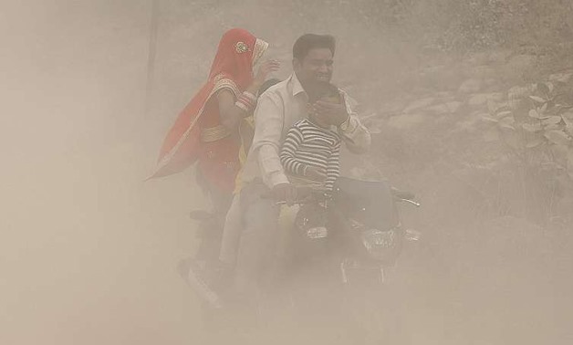 A family riding through the heavy pollution in New Delhi on Sunday, where the poor air has forced a million schoolchildren to stay at home. Mr K. K. Agarwal, president of the Indian Medical Association, has called the current haze blanketing the city a "p