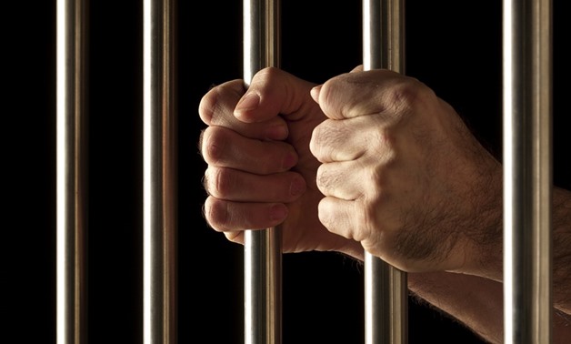 FILE - Man holds prison bars - Pixabay/diegoattorney