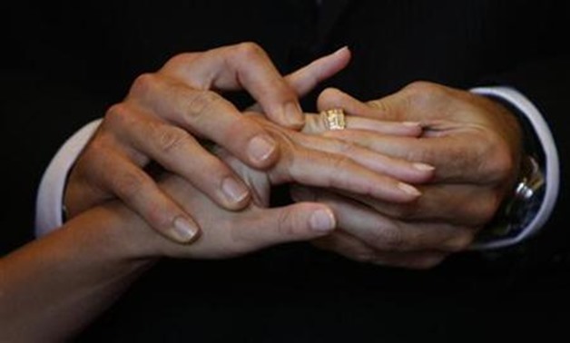 Swiss groom Yann Deleurant puts a wedding ring on his bride Patrizia during their wedding ceremony in the traditional City Hall in Lucerne August 8, 2008. REUTERS/Michael Buholzer


