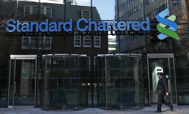 A man walks past the head office of Standard Chartered bank in the City of London February 27, 2015. REUTERS/Eddie Keogh/Files
