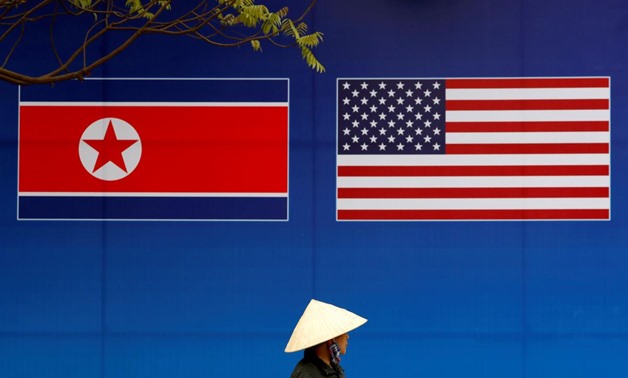 A person walks past a banner showing North Korean and U.S. flags ahead of the North Korea-U.S. summit in Hanoi, Vietnam, February 25, 2019. REUTERS/Kim Kyung-Hoon
