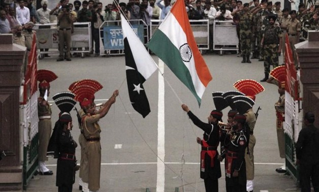 Pakistani rangers (wearing black uniforms) and Indian Border Security Force (BSF) officers lower their national flags during a daily parade at the Pakistan-India joint check-post at Wagah border, near Lahore November 3, 2014. REUTERS/Mohsin Raza/Files