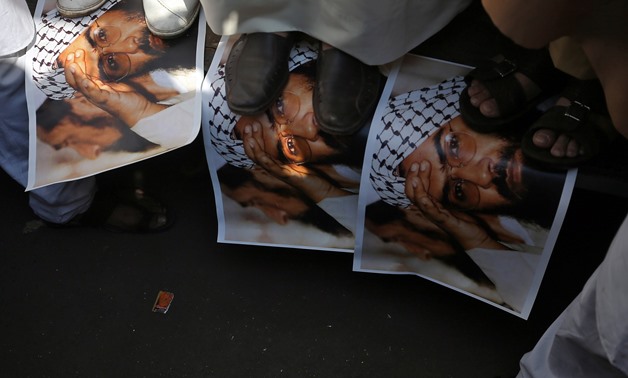 Demonstrators step on the posters of Maulana Masood Azhar, head of Pakistan-based militant group Jaish-e-Mohammad which claimed attack on a bus that killed 44 Central Reserve Police Force (CRPF) personnel in south Kashmir on Thursday, during a protest in 