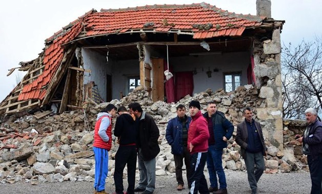Villagers stand in front of a damaged house after two quakes, both with preliminary magnitudes of 5.3, jolted Turkey's northern Aegean coast. (File photo: AP)