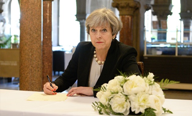 Britain's Prime Minister Theresa May writes a message for the book of condolences for the victims of the attack on Manchester Arena. REUTERS/Ben Birchall/Pool