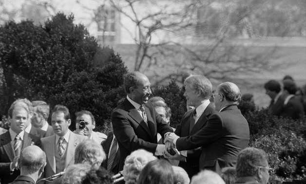 Anwar Sadat, Jimmy Carter, and Menachem Begin shaking hands on the White House grounds – Warren K. Leffler