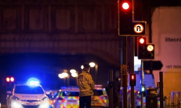 Police vehicles and a police officer are seen outside the Manchester Arena - REUTERS