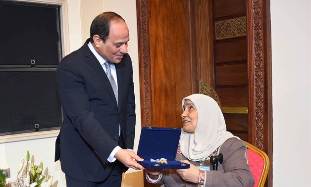 President Abdel Fatah al-Sisi honors one of ideal mothers on the Egyptian Woman Day- press photo
