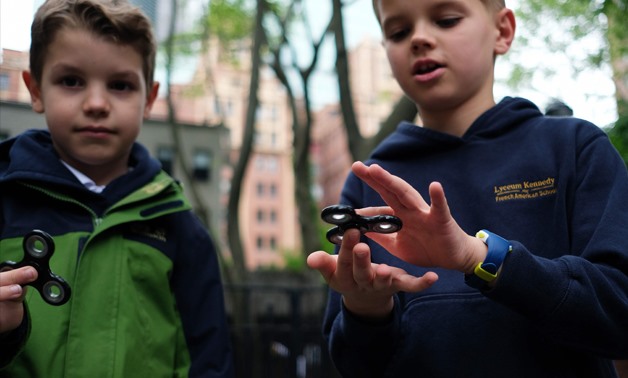 
Eight-year-old Tom Wuestenberg (L) and his ten-year-old brother Louis play with fidget spinners - AFP/JEWEL SAMAD 