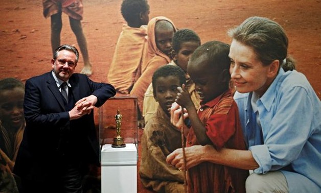 Sean Hepburn Ferrer, poses in front of a picture of his mother Audrey Hepburn and an Oscar statuette awarded posthumously for her humanitarian work at the exhibition "Intimate Audrey" in Brussels, Belgium, May 2, 2019. REUTERS/Francois Lenoir.
