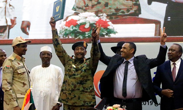 Sudan's Head of Transitional Military Council, Lieutenant General Abdel Fattah Al-Burhan, and Sudan's opposition alliance coalition's leader Ahmad al-Rabiah, celebrate the signing of the power sharing deal, that paves the way for a transitional government