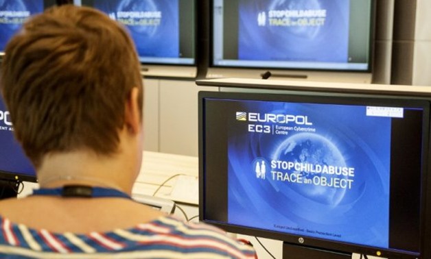 A Europol police agent looks at the onscreen logo of a new website launched by Europol at the Europol headquarters in The Hague on May 31, 2017. A particular shampoo brand, a magazine cover, a shopping bag or even a pattern on wallpaper are some clues Eur