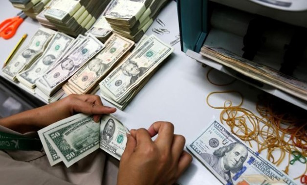 A bank employee counts U.S. dollar notes at a Kasikornbank - REUTERS/Athit Perawongmetha