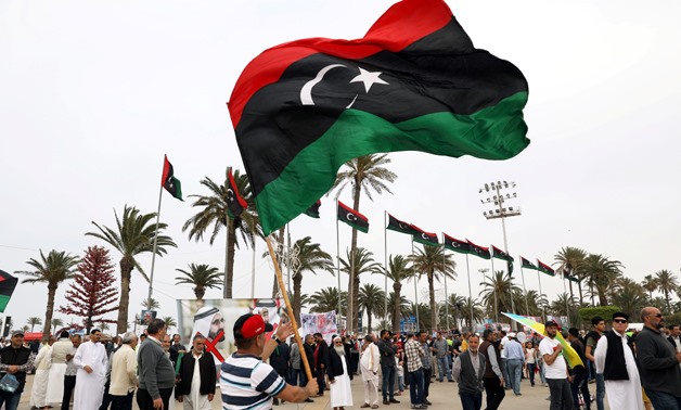 FILE PHOTO: A Libyan man waves a Libyan flag during a demonstration to demand an end to the Khalifa Haftar's offensive against Tripoli, in Martyrs' Square in central Tripoli, Libya April 26, 2019. REUTERS/Ahmed Jadallah - RC116B00BE60/File Photo