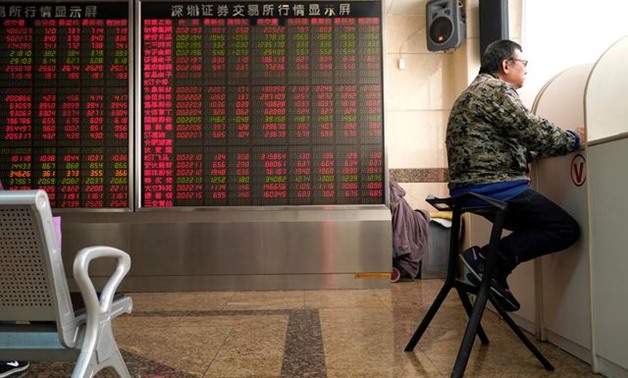 An investor sits next to a stock quotation board at a brokerage office in Beijing, China January 3, 2020. REUTERS/Jason Lee

