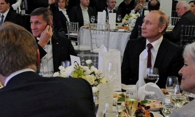 Vladimir Putin (R) sat next to Michael Flynn (L) - REUTERS
