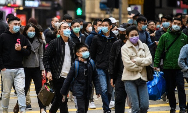 FILE- Pedestrians wearing face masks cross a road during a Lunar New Year of the Rat public holiday in Hong Kong on January 27, 2020, as a preventative measure following a coronavirus outbreak which began in the Chinese city of Wuhan
