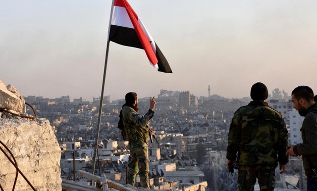 Syrian forces raise their flag over an area of Aleppo (Reuters)
