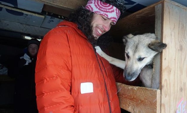 Musher Sean Underwood, a dog handler who became a last-minute substitute for four-time champion Jeff King after the latter had emergency surgery, greets the team inside King's dog truck in downtown Anchorage at the start of the 2020 Iditarod Trail Sled Do