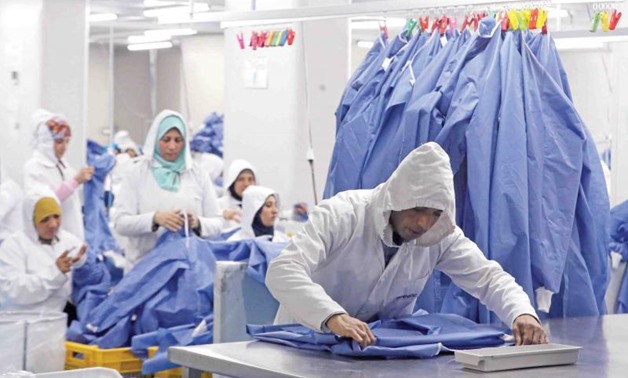 Workers are seen in a factory that produces sterilised surgical equipment and medical clothing in Sadat, Egypt, March 15. (Reuters)