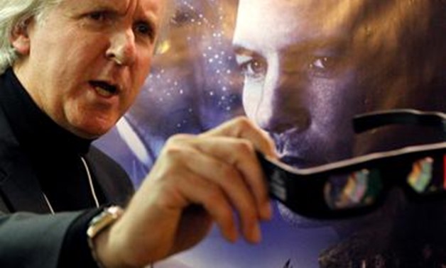 FILE PHOTO: Canadian director James Cameron shows 3D glasses as he poses in front of a poster before a promotion event for his latest movie Avatar at the World Economic Forum (WEF), in Davos January 28, 2010. REUTERS/Christian Hartmann/File Photo.
