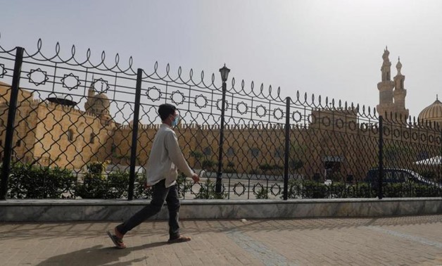 FILE - A man walks past the closed al-Azhar Mosque in Cairo which has been closed along with other places of worship to stop the spread of coronavirus in Egypt – Reuters