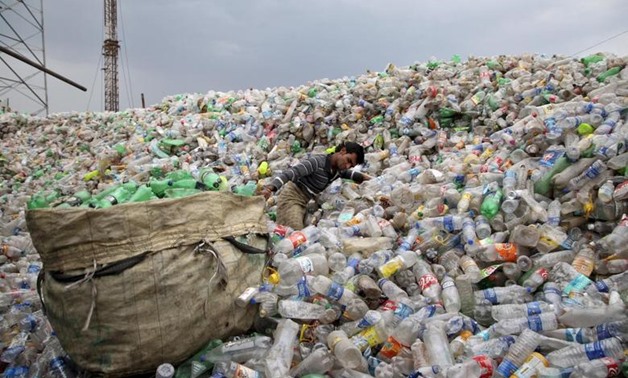 A man pulls a sack filled with empty bottles at a plastic junkyard in Chandigarh, June 5, 2015. REUTERS/Ajay Verma