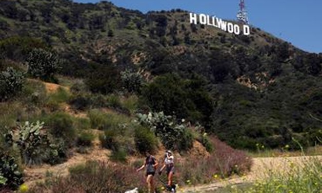 FILE PHOTO: People hike beneath the Hollywood sign after a partial reopening of Los Angeles hiking trails during the outbreak of the coronavirus disease (COVID-19) in Los Angeles, California, U.S., May 9, 2020. REUTERS/Patrick T. Fallon/File Photo.
