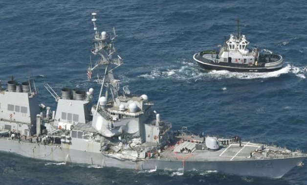The Arleigh Burke-class guided-missile destroyer USS Fitzgerald, damaged by colliding with a Philippine-flagged merchant vessel, is seen next to a tugboat (R) off Shimoda, Japan in this photo taken by Kyodo June 17, 2017 - REUTERS