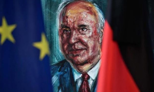 A European (L) and a German flag frame the official portrait of former German Chancellor Helmut Kohl on display at the Chancellery in Berlin on June 18, 2017 CREDIT: JOHN MACDOUGALL/AFP