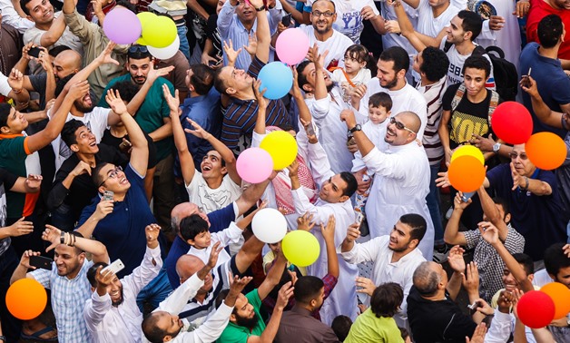 Cover photo - People trying to catch flying balloons after Eid prayer at el-Seddik Mosque in Sheraton, Cairo - Hazim Abdel Samad