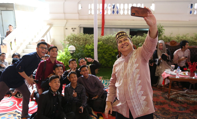 Ambassador Helmy Fawzy takes a selfie photo with Indonesian students in celebration of Eid alFitr at the embassy headquarters- press photo